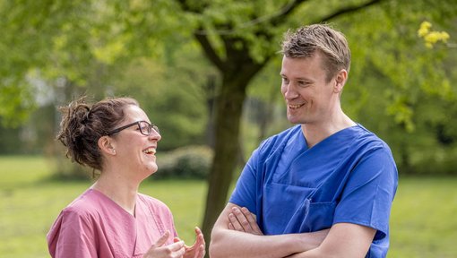 Zwei Klinikmitarbeitende unterhalten sich im Garten