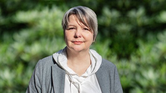 Portrait Ulrike Matthiensen vor Blaetterhintergrund