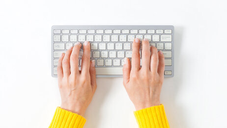 Abbildung Hände über Computertastatur